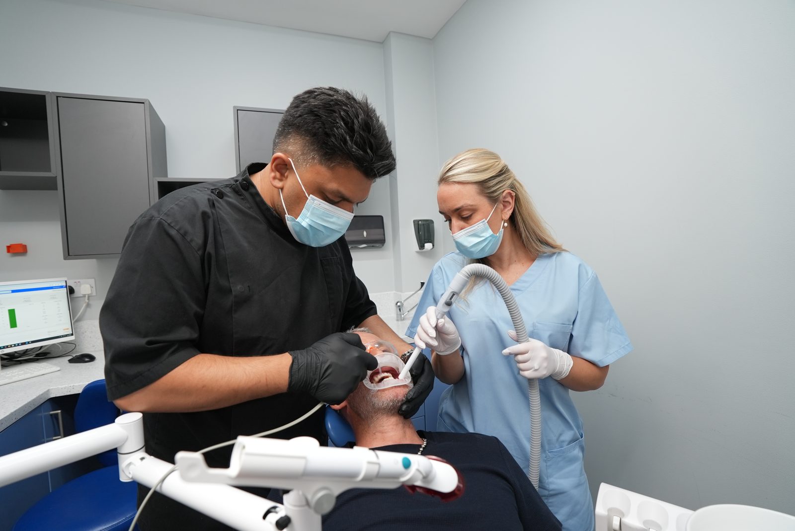 Dentist carrying out treatment with a nurse assisting at Welling Dental Studio