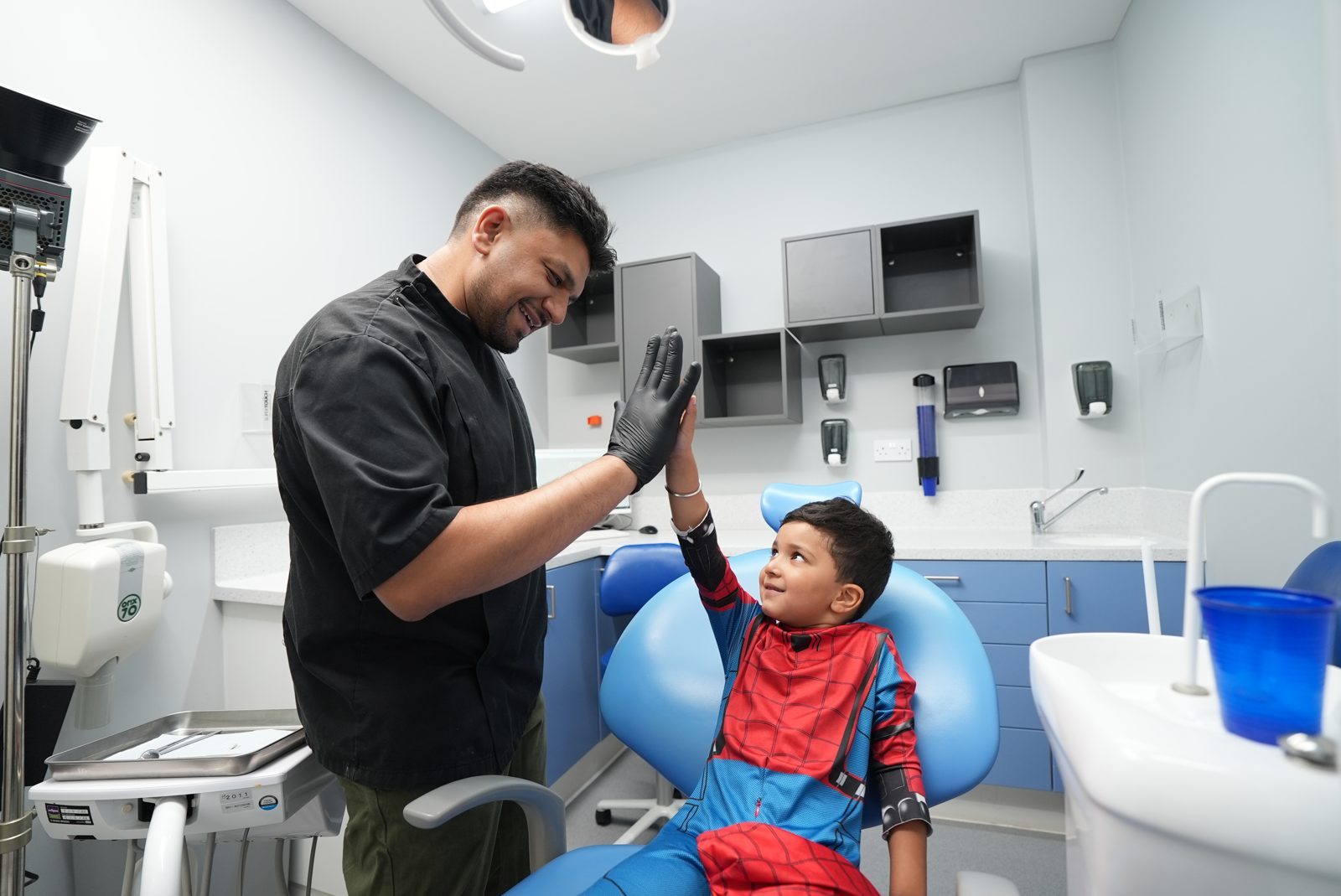 Dentist high-fiving a young patient in the treatment room at Welling Dental Studio